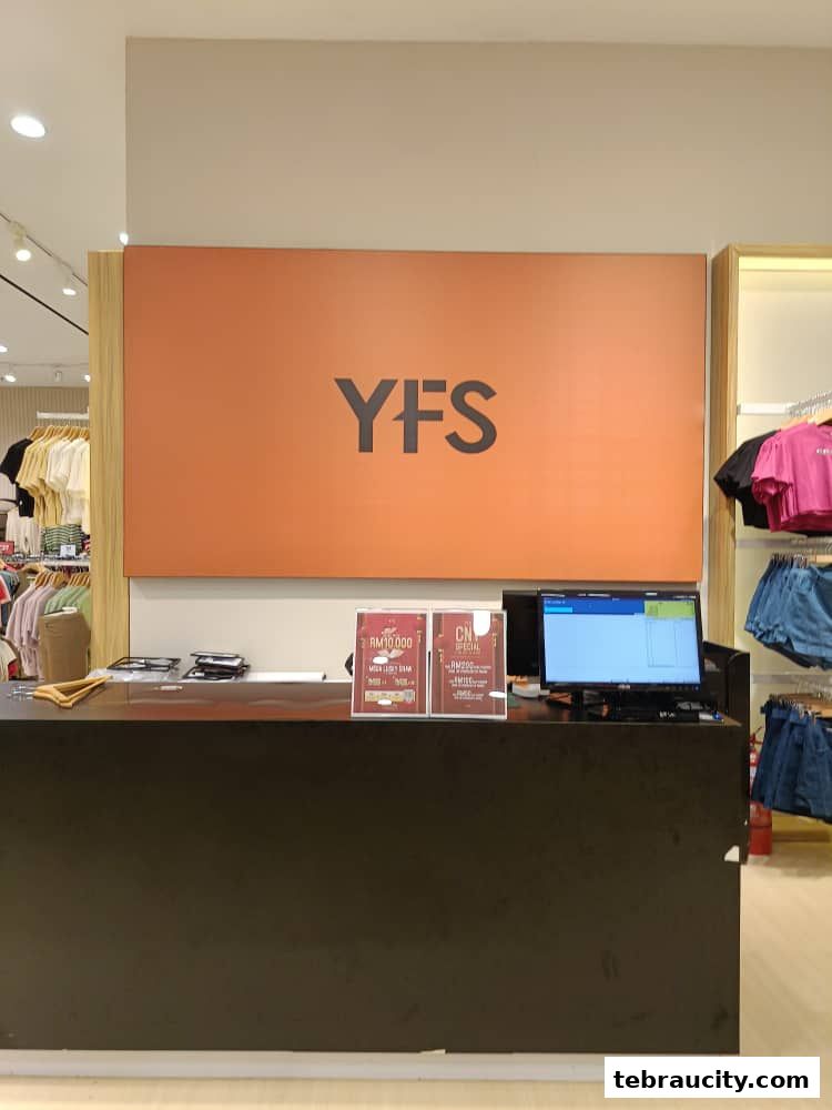 The YFS Concept Store counter with promotional signs and a computer monitor.
