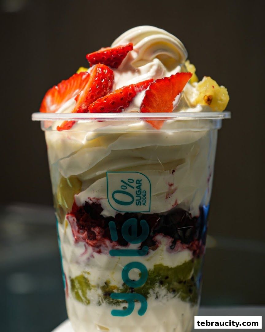 A delicious frozen yogurt parfait with fresh strawberries, kiwi, and berries.