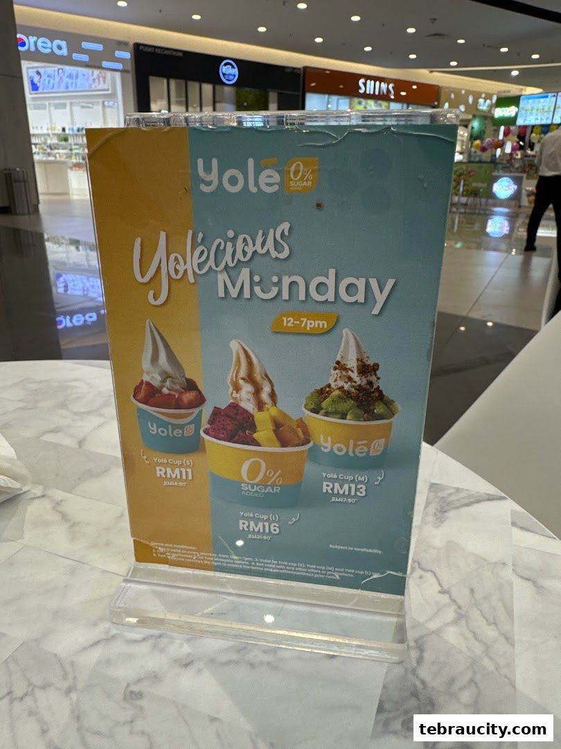 A Yolé promotional sign for 'Yolelicious Monday' featuring three different frozen yogurt cups.