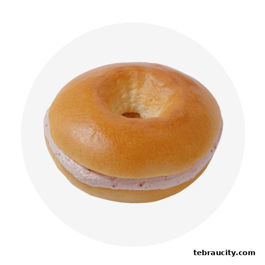 A close-up shot of a delicious bagel filled with creamy strawberry filling.