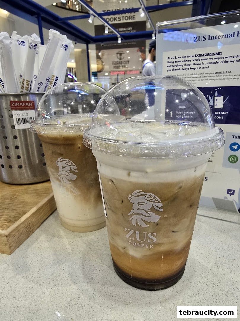 Two iced coffee drinks from ZUS Coffee with the brand logo visible on the cups.
