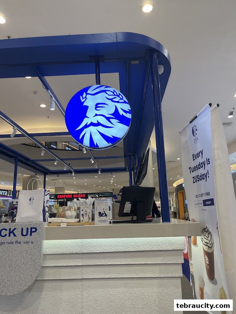 The ZUS Coffee counter with its distinctive blue logo and promotional banner.