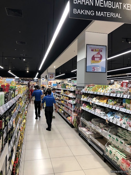 An aisle in a grocery store with shelves stocked with various products.